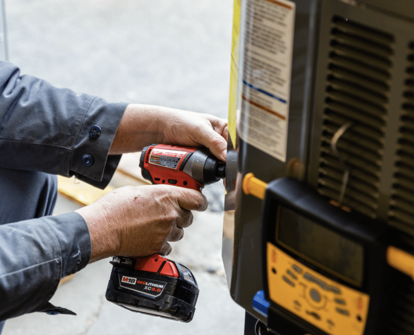 DFH HVAC technician performing equipment maintenance on an outdoor condenser