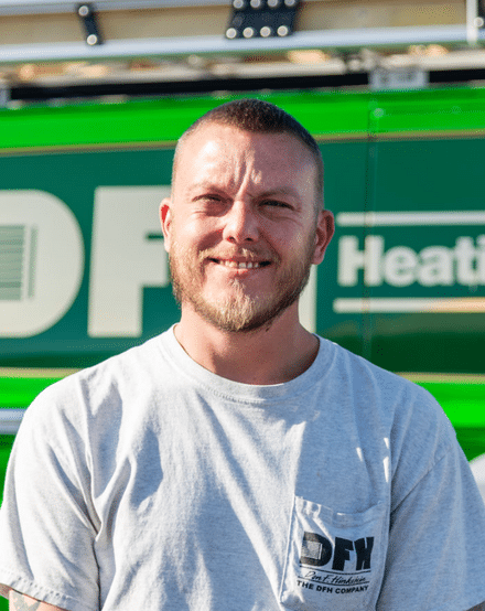 Portrait of a DFH technician in front of a green van