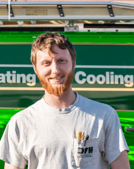 Portrait of a DFH technician in front of a green van