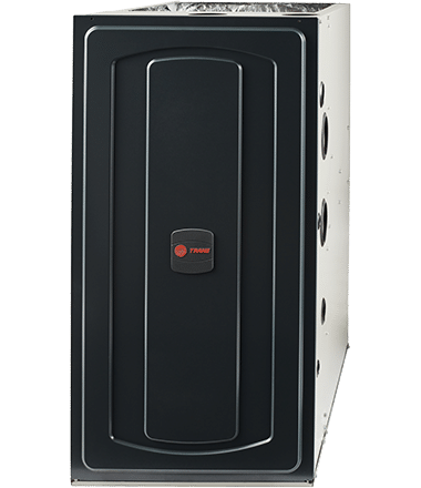 A Trane brand residential furnace unit with a dark grey or black front panel and the red Trane logo in the center.